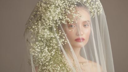 Bride wearing a wedding beauty look with a floral veil