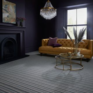 Dark purple living room with striped grey carpet and chesterfield style sofa