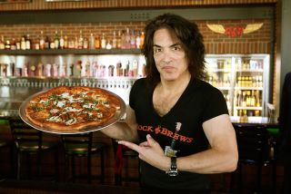 Pizza the action: Stanley at one of his Rock & Brews restaurants, displaying something from the menu