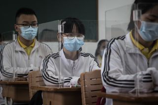 These senior-year students in Wuhan, China where the outbreak first began, returned to school in May with precautionary measures put in place to curb the spread of the virus. Here they are shown at their desks on May 6 behind transparent boards.