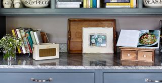 Kitchen countertop with purposefully displayed cookbooks with a recipe stand showing an open book demonstrating the key to organizing kitchen countertops with books