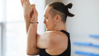 A man doing a shoulder stretch in yoga