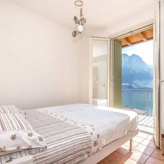 bed with lush green mountains and tiles flooring