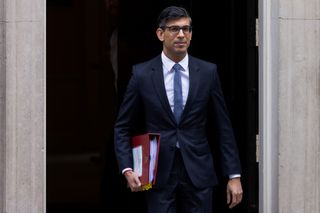 Rishi Sunak leaving number 10 Downing Street with a folder under his arm whilst in a black suit and tie
