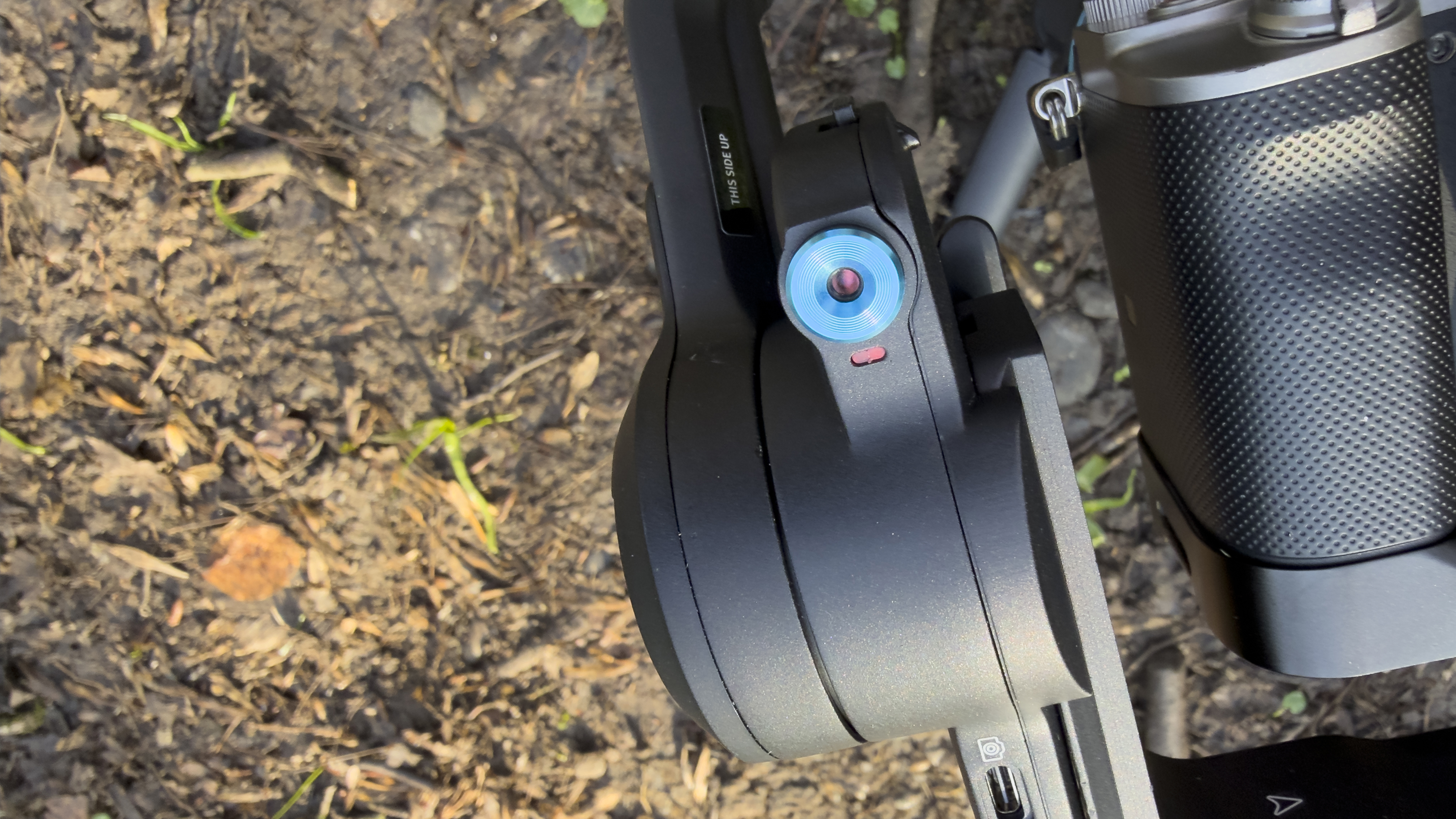 Close-up of a gimbal motor and blue control dial beside a mounted camera