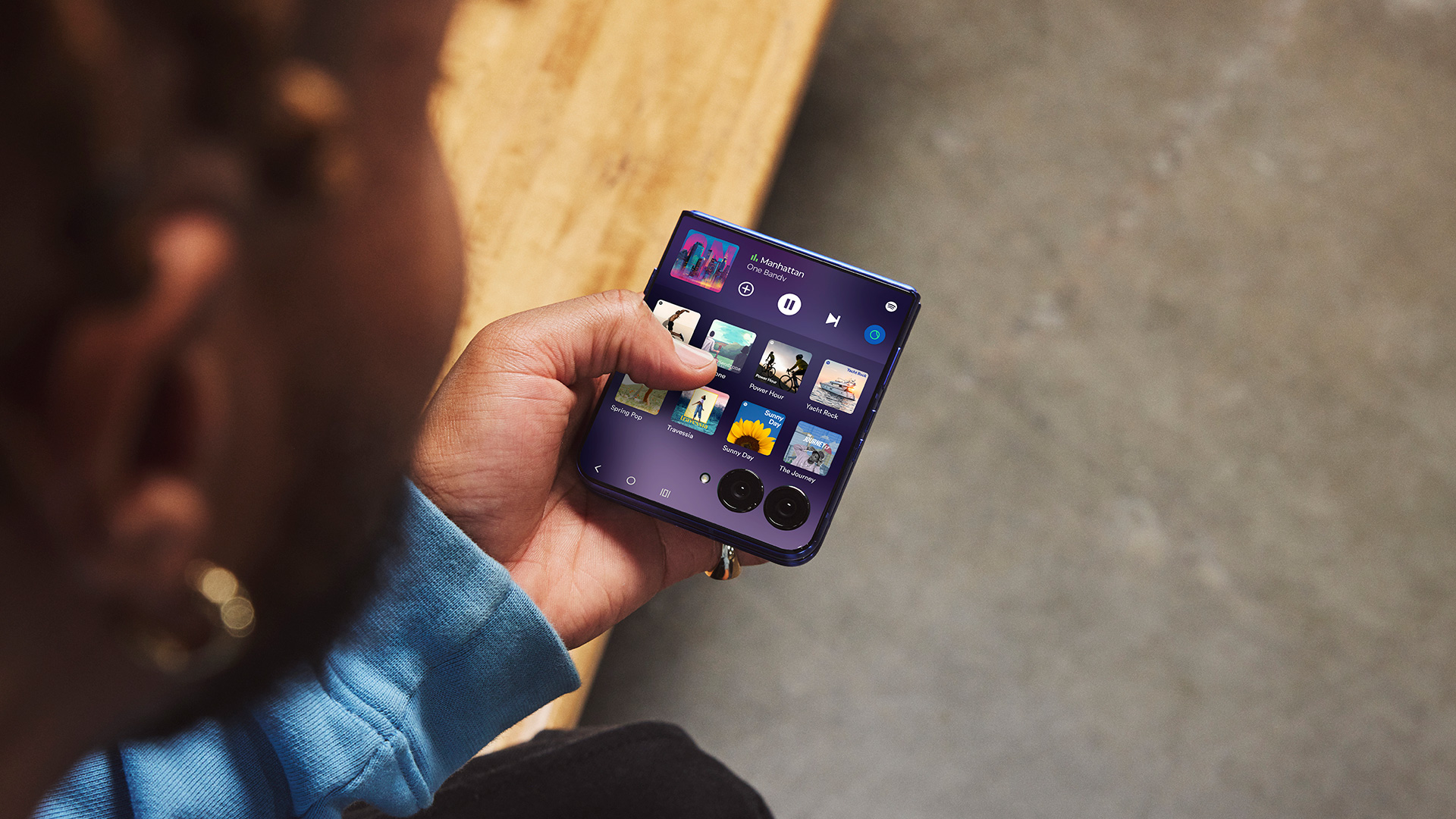 Person using Motorola Razr 70 Ultra's outer display to browse Spotify