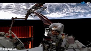 a chinese astronaut on a spacewalk waves to the camera with earth in the background