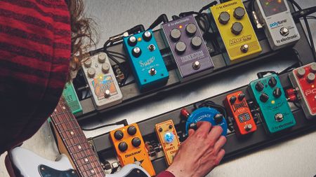 Portrait of a guitarist alongside a pedal board and numbers guitar effects pedals, taken on May 15, 2017.