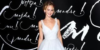 Jennifer Lawrence wearing a wedding style dress on the red carpet.