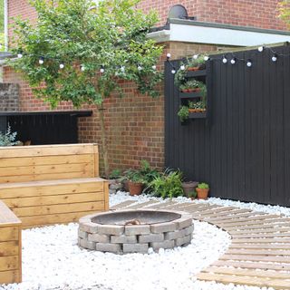 exterior of house with black gate wooden bench and brick wall