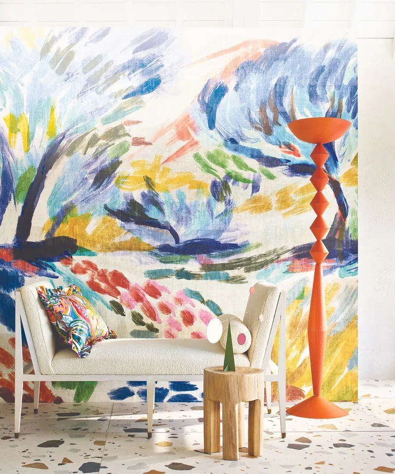 Wallpaper with trees, orange lamp and cream sofa