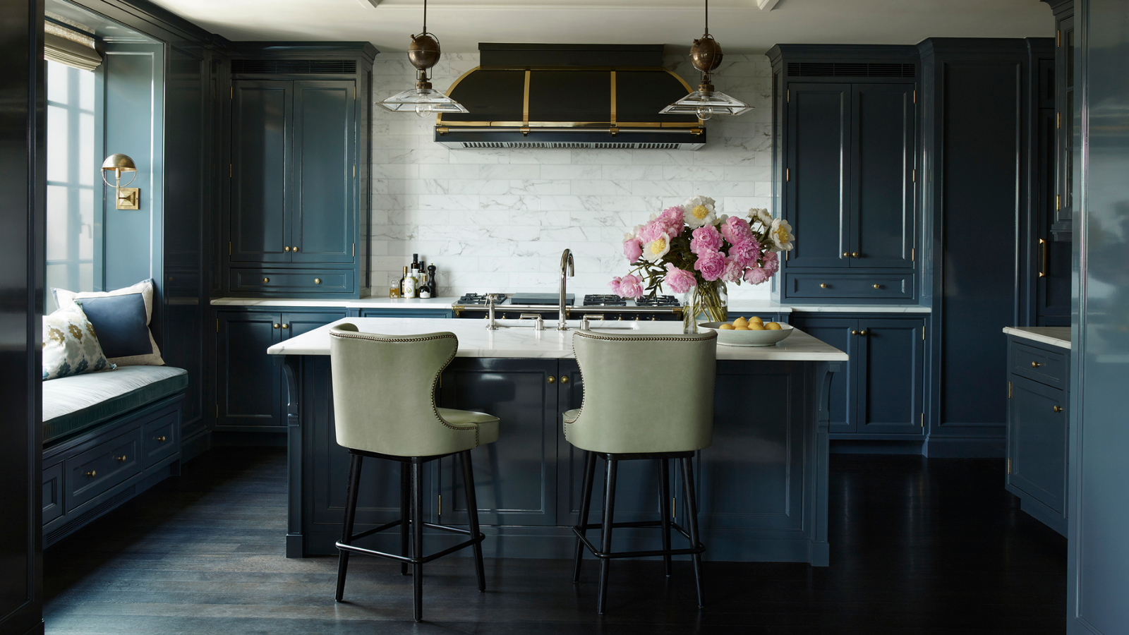 a kitchen with cabinets painted with high gloss blue paint, white countertops, a white backsplash, and two barstools in a sage green color