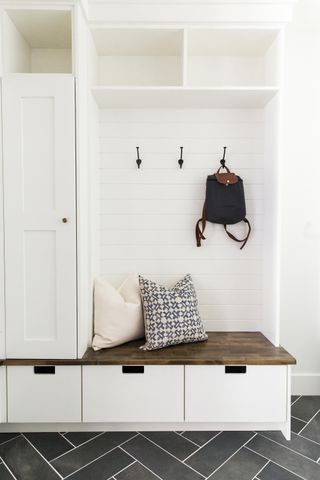 white mudroom/hallway storage with bench and grey herringbone floor tiles