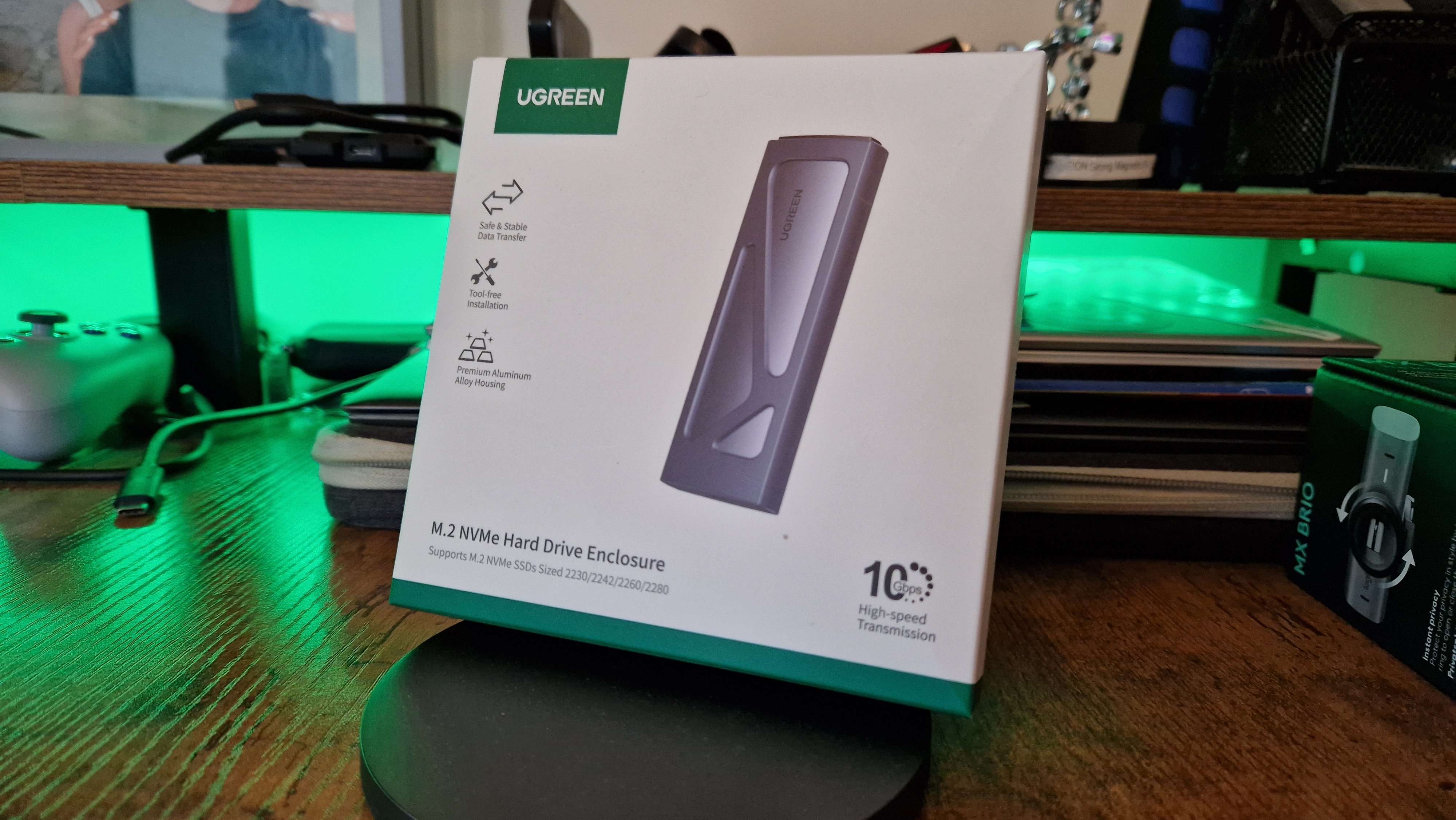 Ugreen's NVMe SSD enclosure in front of some green RGB lighting