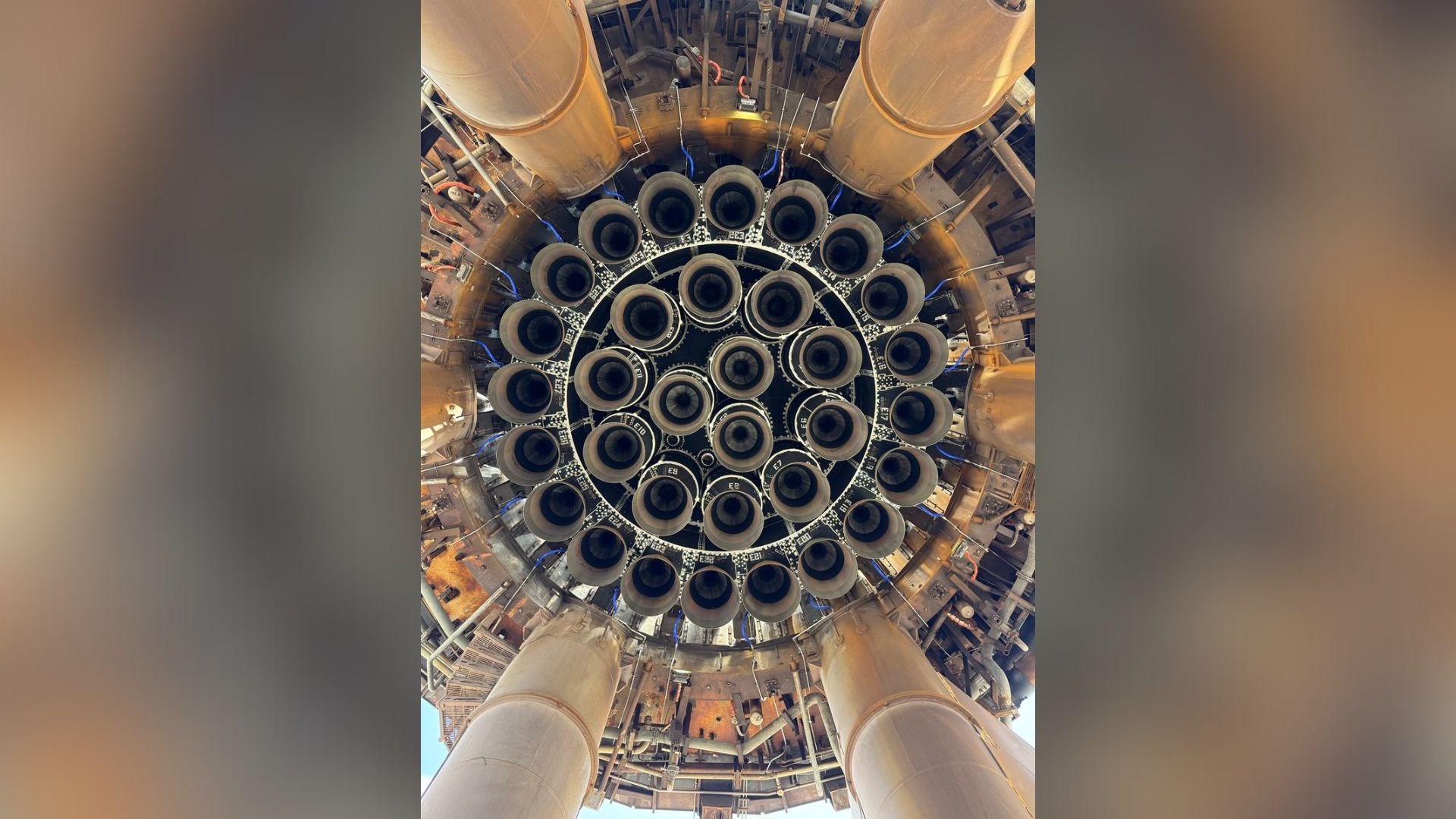 从下方33个饥饿的SpaceX猛禽|2025年9月1日每日太空照片 A view looking up at underneath SpaceXs Starship spacecraft. A series of circular engines make a dizzying array.