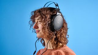 the FiiO JT3 headphones in black and silver shown against a blue tom's guide background