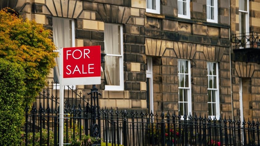 For sale sign outside a row of terraced houses