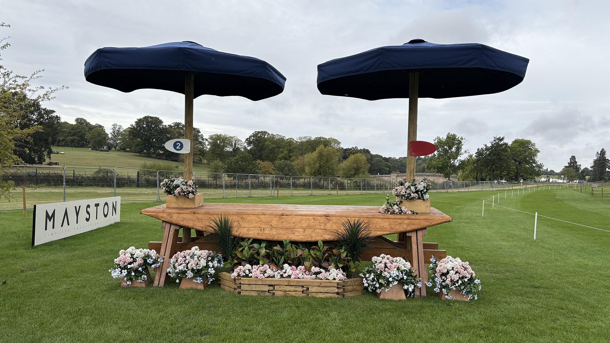 Table fence decorated with blue umbrellas on the Burghley cross-country course 2026