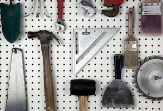 A white pegboard with tools attached