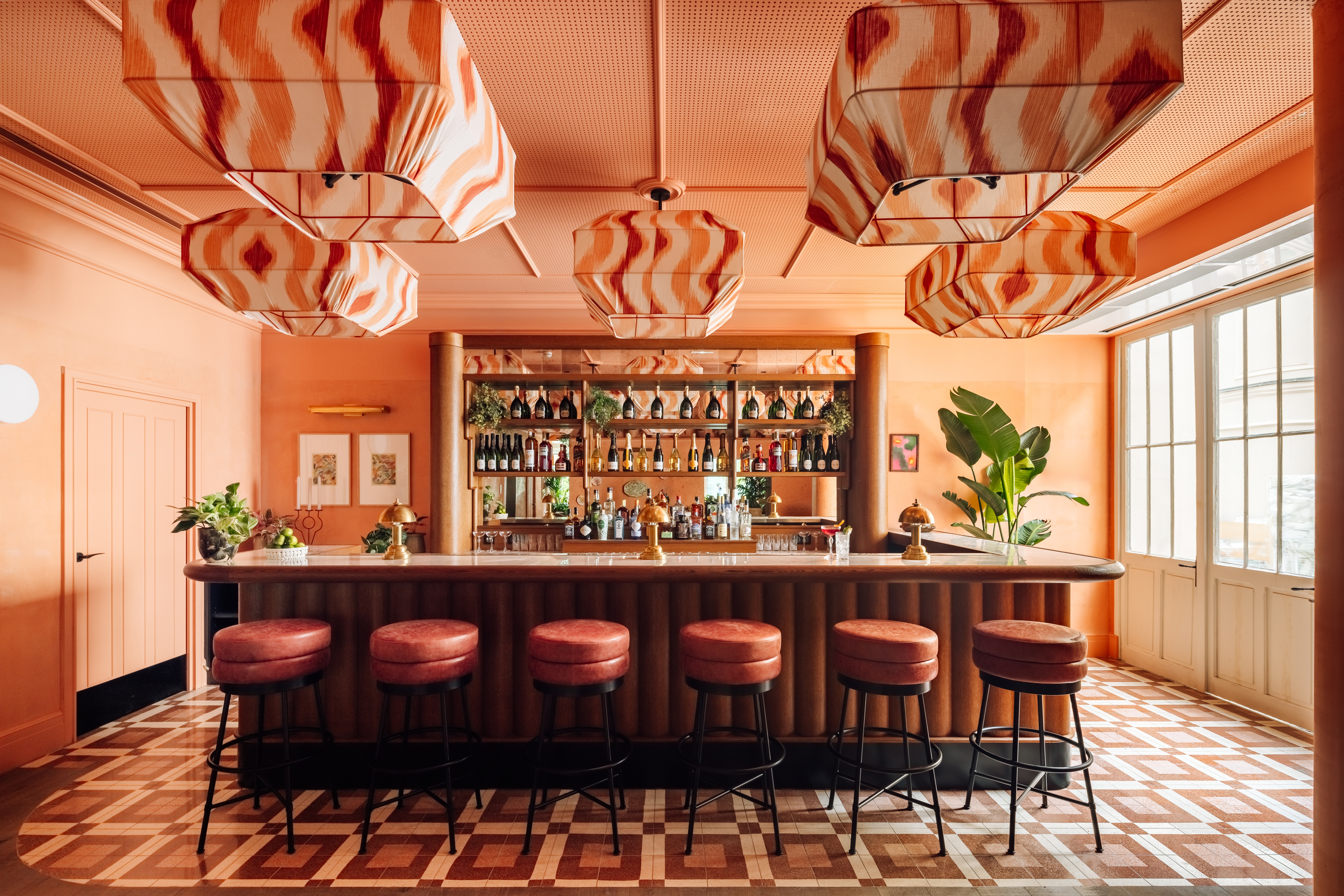 A brightly decorated, patterns and plush textiles-filled hotel's rooms and common spaces feature an earthy palette ranging from ochre and green to terracotta, orange, and brown.