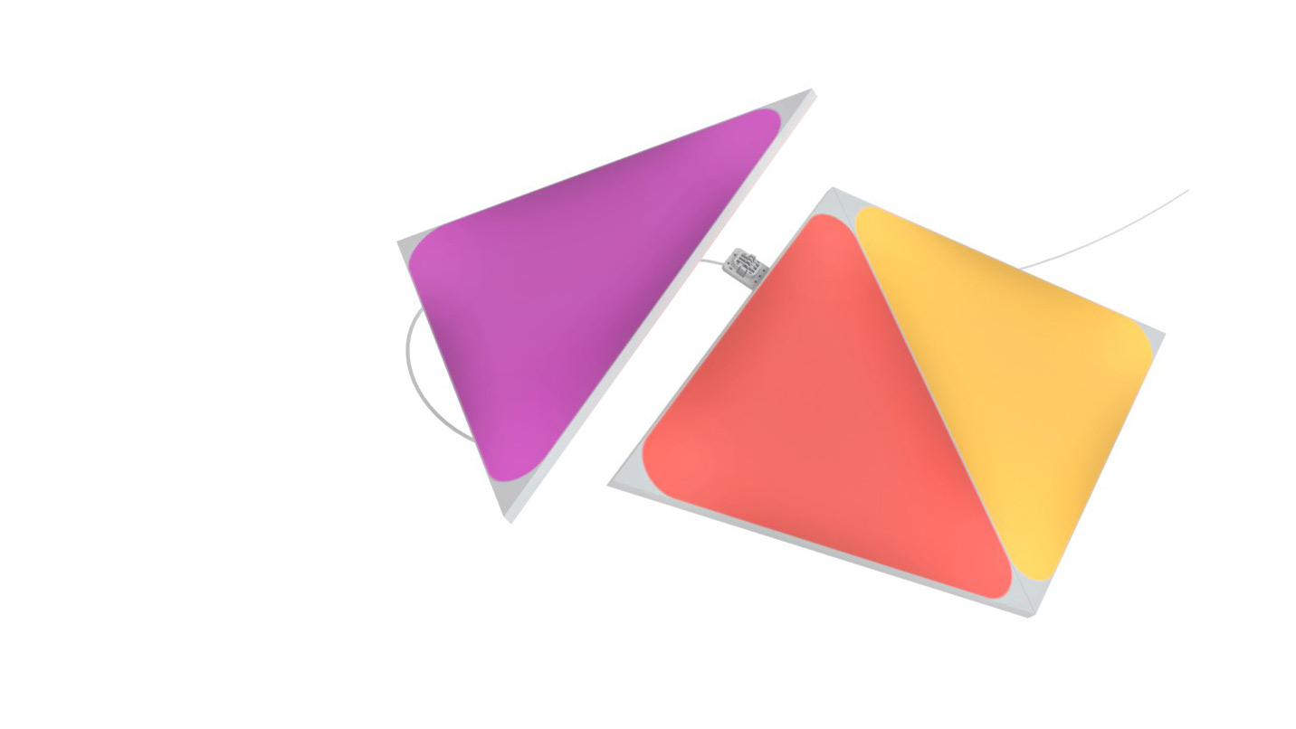 The Nanoleaf Shapes triangle light panels illuminate pink, orange and yellow on a white background