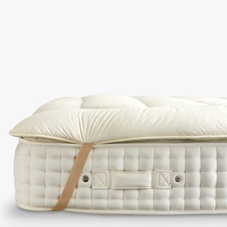 Wool mattress topper with straps on a mattress