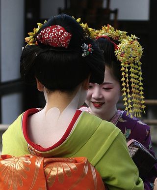 Two young geisha with traditional hairstyles.