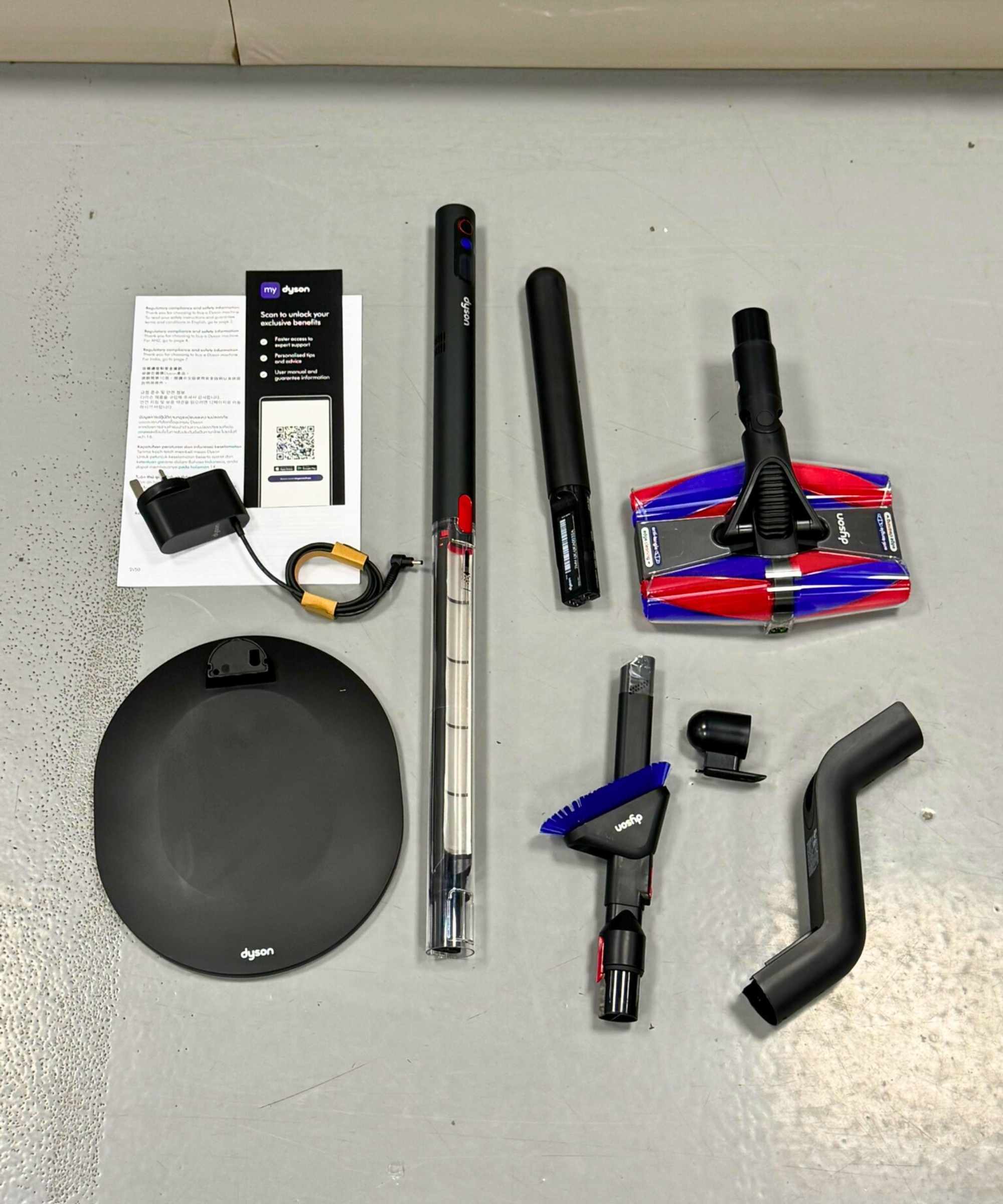 All parts for the Dyson PencilVac Fluffycones laid out on gray floor.