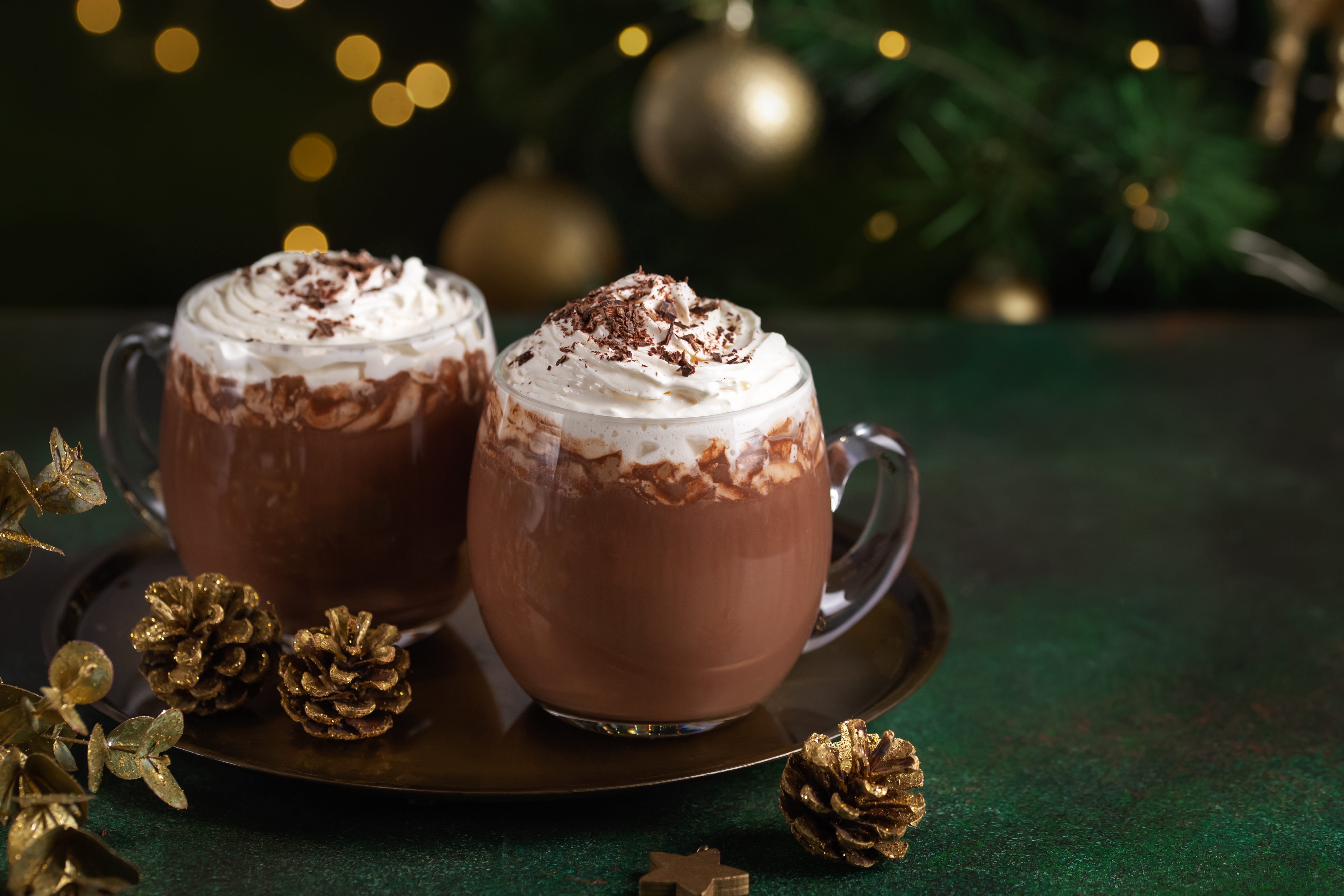 a christmas drink hot chocolate served in glass mugs with whipped cream