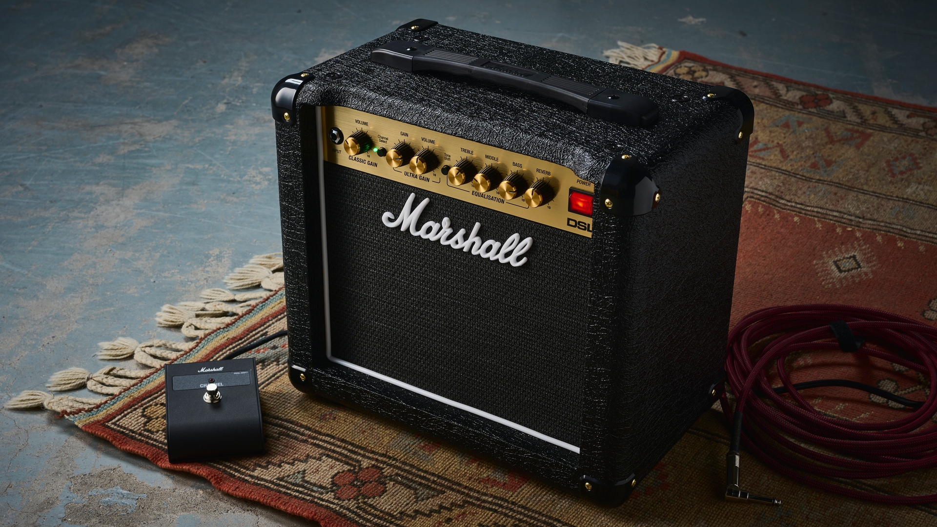 A Marshall DSL1CR tube amp on a rug with its dedicated foot switch