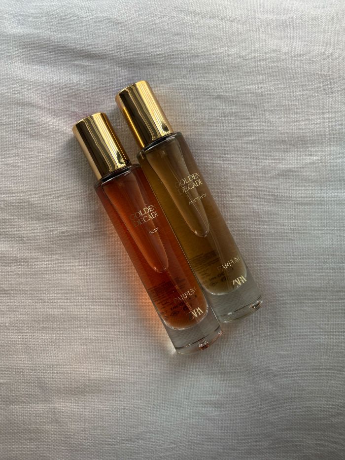 Two Zara Golden Decade perfumes on a white linen background