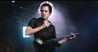 Kirk Hammett in 1996, playing Lollapalooza with Metallica lit from behind with his ESP single-cut.