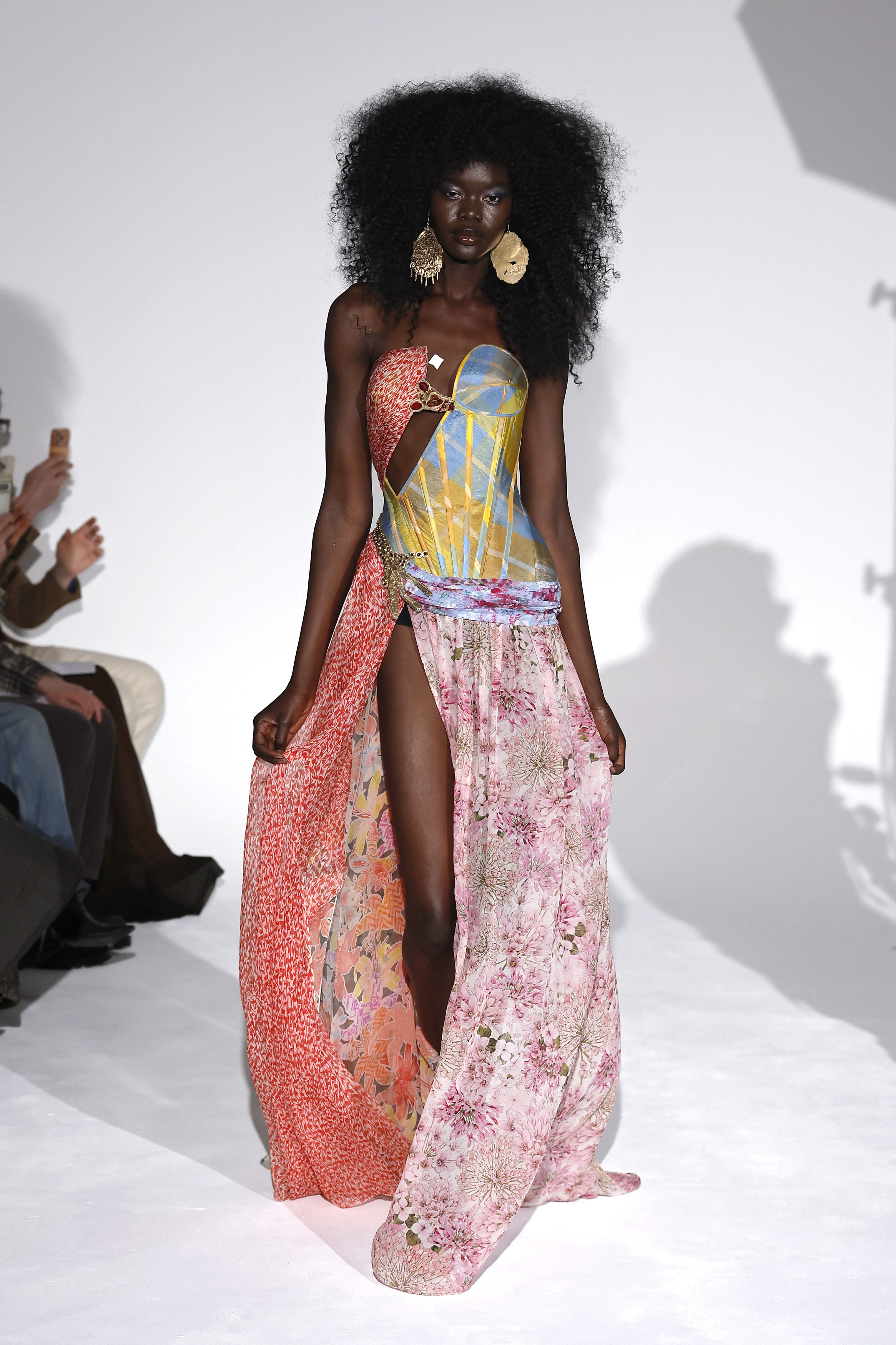 a black woman with long, dark hair models on a runway
