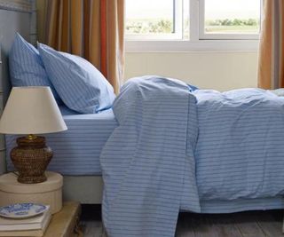 Pale Blue Favorite Shirt Stripe Cotton Sheets on a bed.