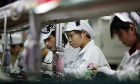 Employees work on the assembly line at the Foxconn factory in China: The reported grueling conditions at Apple parts supplier could taint the tech giant&amp;#039;s reputation.