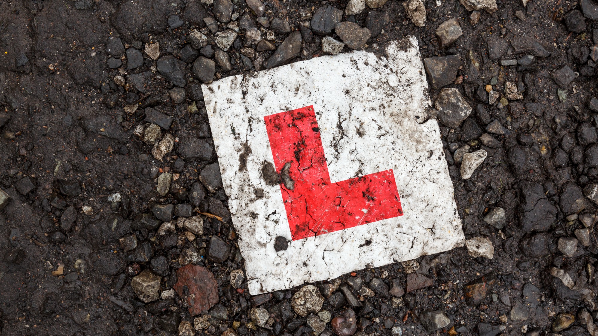 A learner driver&rsquo;s L-plate discarded on the ground
