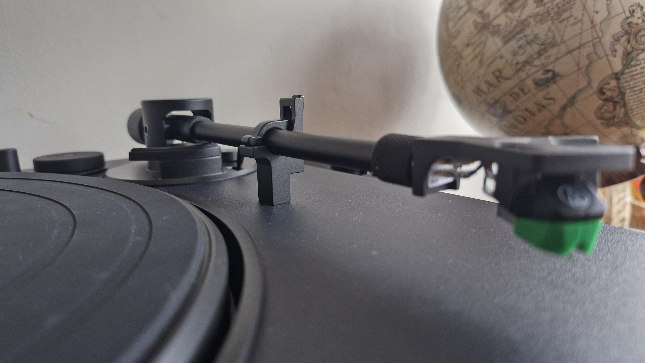 A close-up of the arm of the Victrola Hi-Res Onyx record player