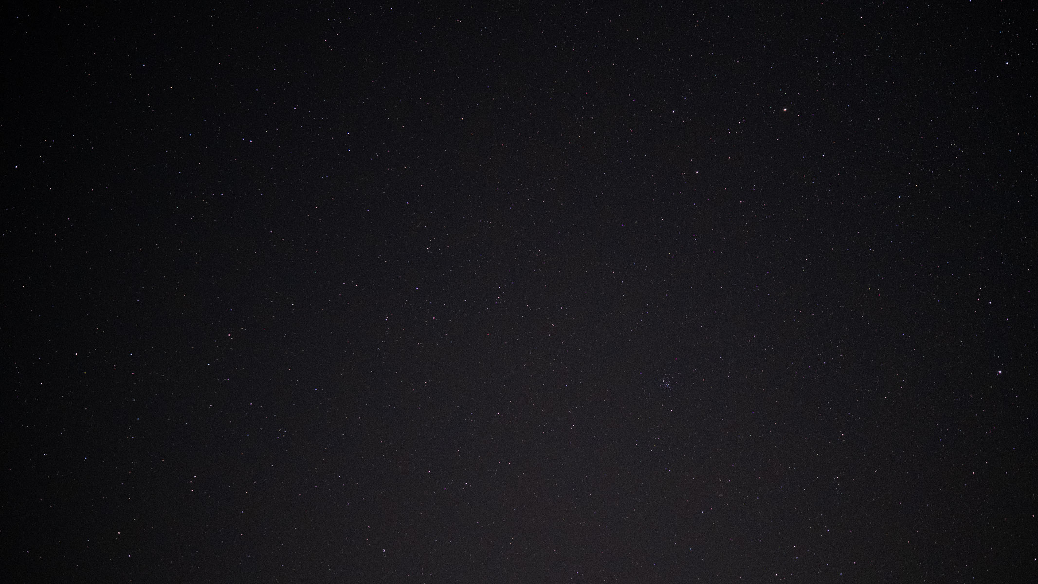 Stars in the night sky with the Beehive Cluster.