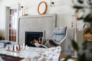 Grey fireplace with grey armchair next to it
