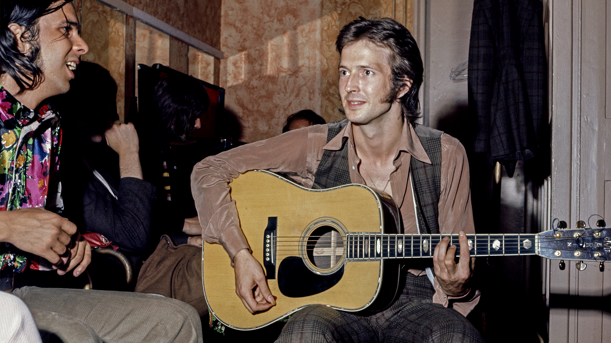 Eric Clapton (right, playing a Martin acoustic guitar) and Bobby Whitlock (left) of Derek and The Dominos, backstage before the band's live debut at the Lyceum Theatre, London, 14th June 1970.