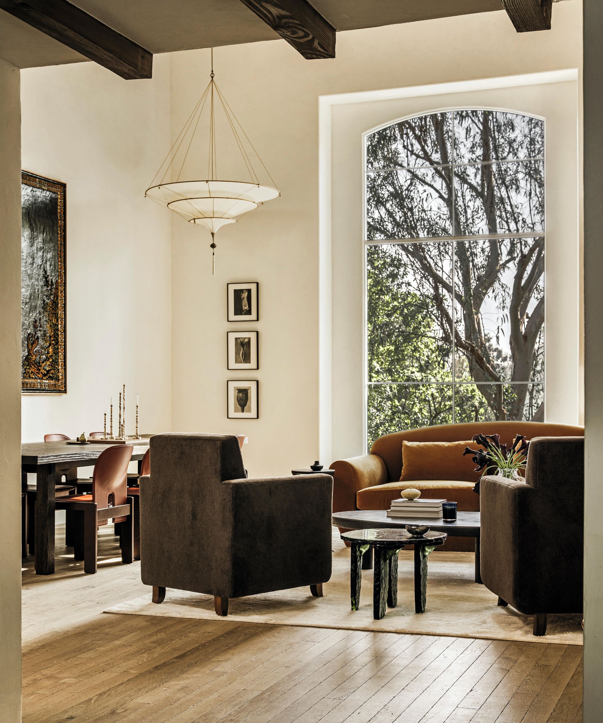 a neutral light filled sitting room with toffee coloured furniture and large window