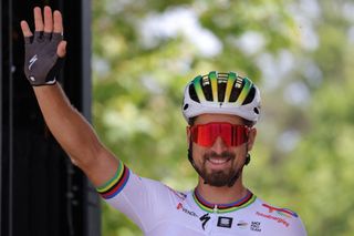 TotalEnergies' Slovakian rider Peter Sagan waves as he awaits the start of the 13th stage of the 110th edition of the Tour de France cycling race, 138 km between Chatillon-sur-Chalaronne in central-eastern France and Grand Colombier, in the Jura mountains in Eastern France, on July 14, 2023. (Photo by Thomas SAMSON / AFP)