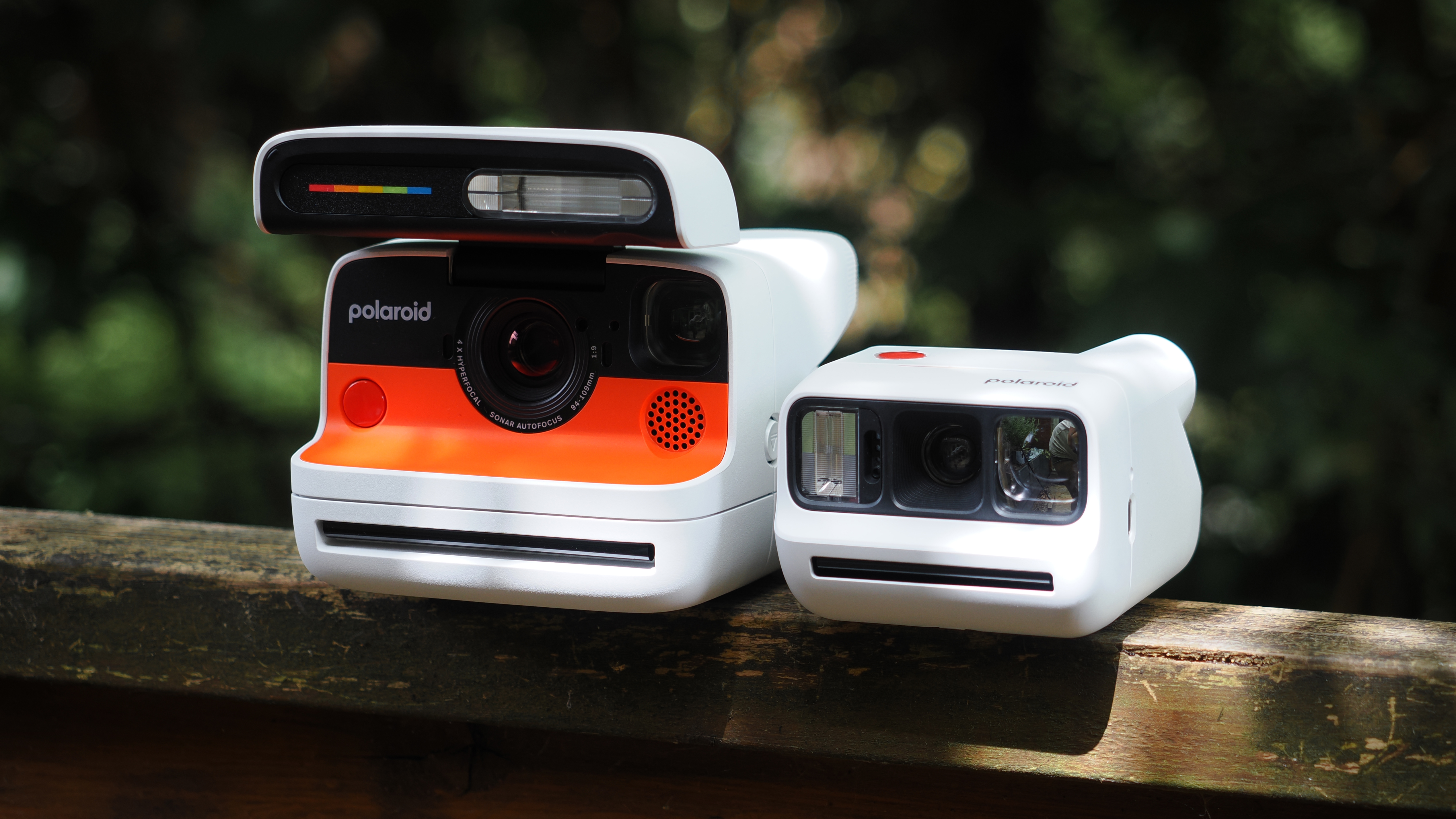 Polaroid Flip next to a Polaroid Go Gen 3 on a wooden surface, outdoors
