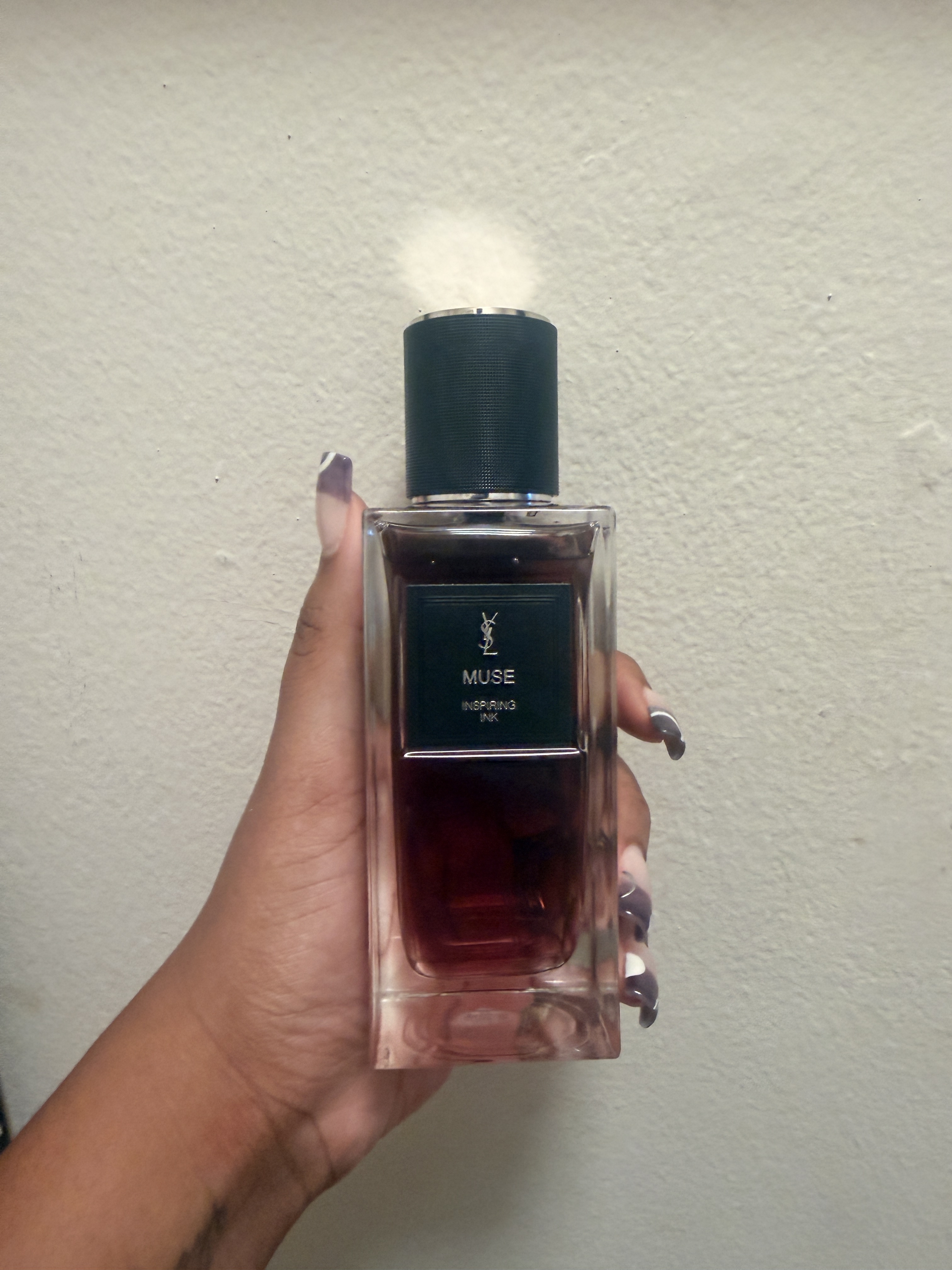 A bottle of YSL Muse, held by beauty writer, Ariel Baker.