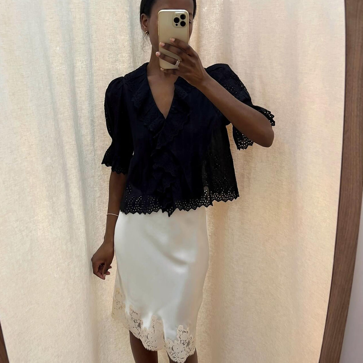 Woman in a black top and lace-trim midi skirt