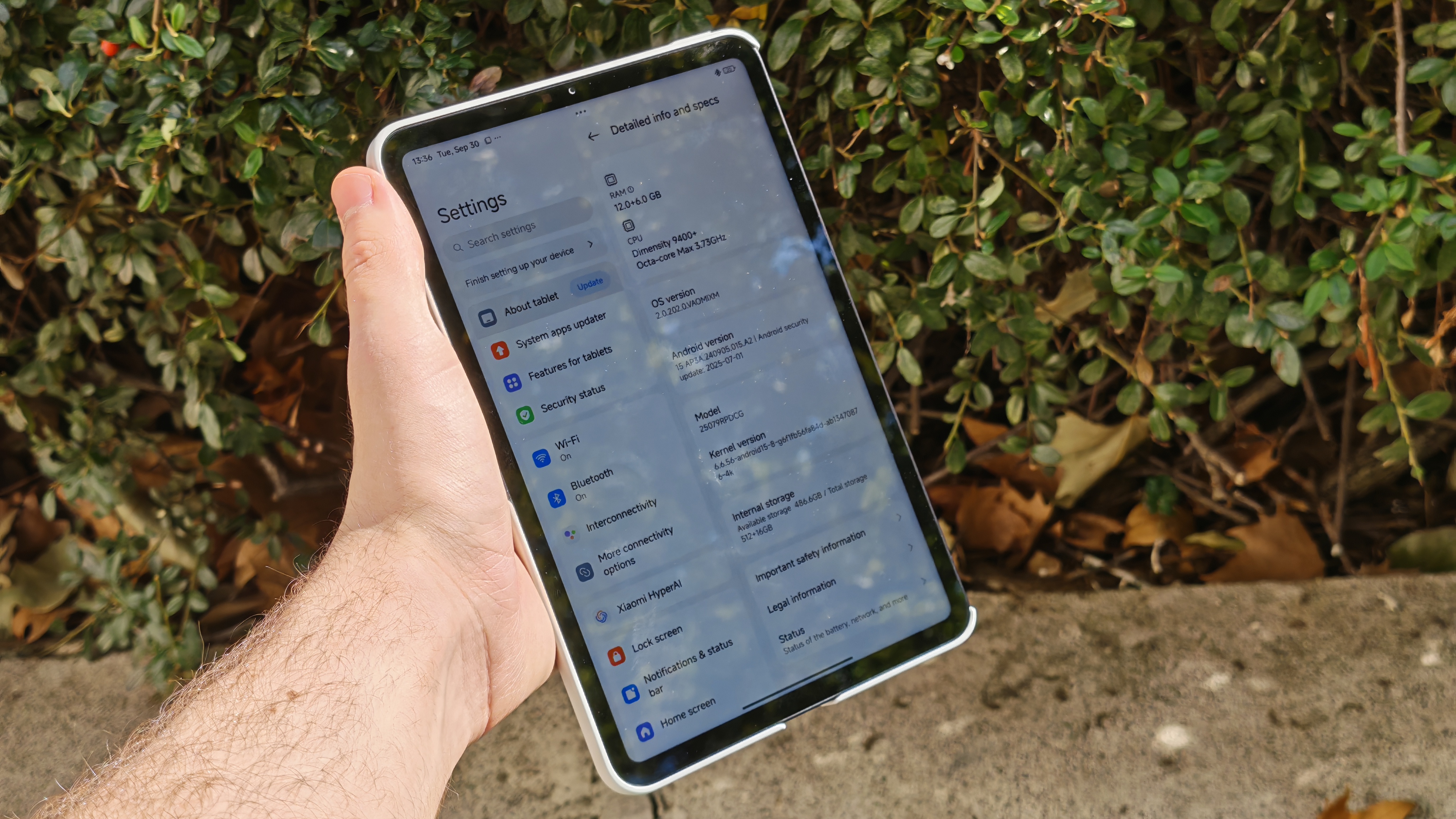 Xiaomi Pad Mini open to settings app, greenery in background