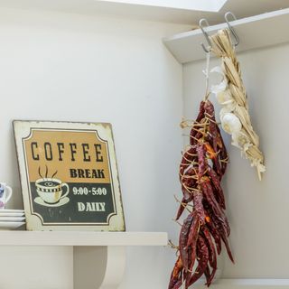 Dried chillies hung in a white pantry