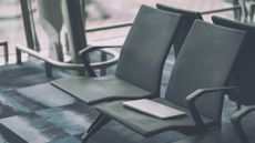 Lost devices concept image showing a laptop left behind on a seat in an airport terminal.