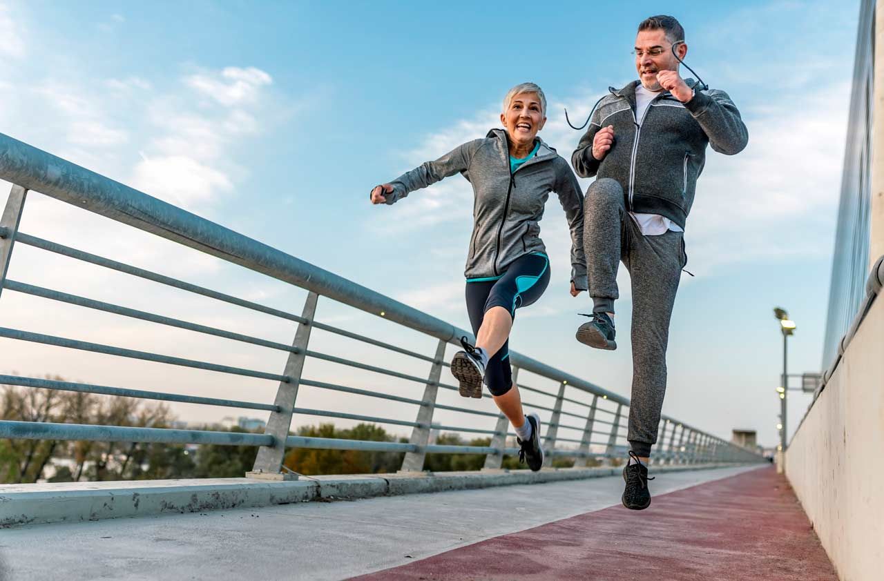 A retired couple skips along a walkway