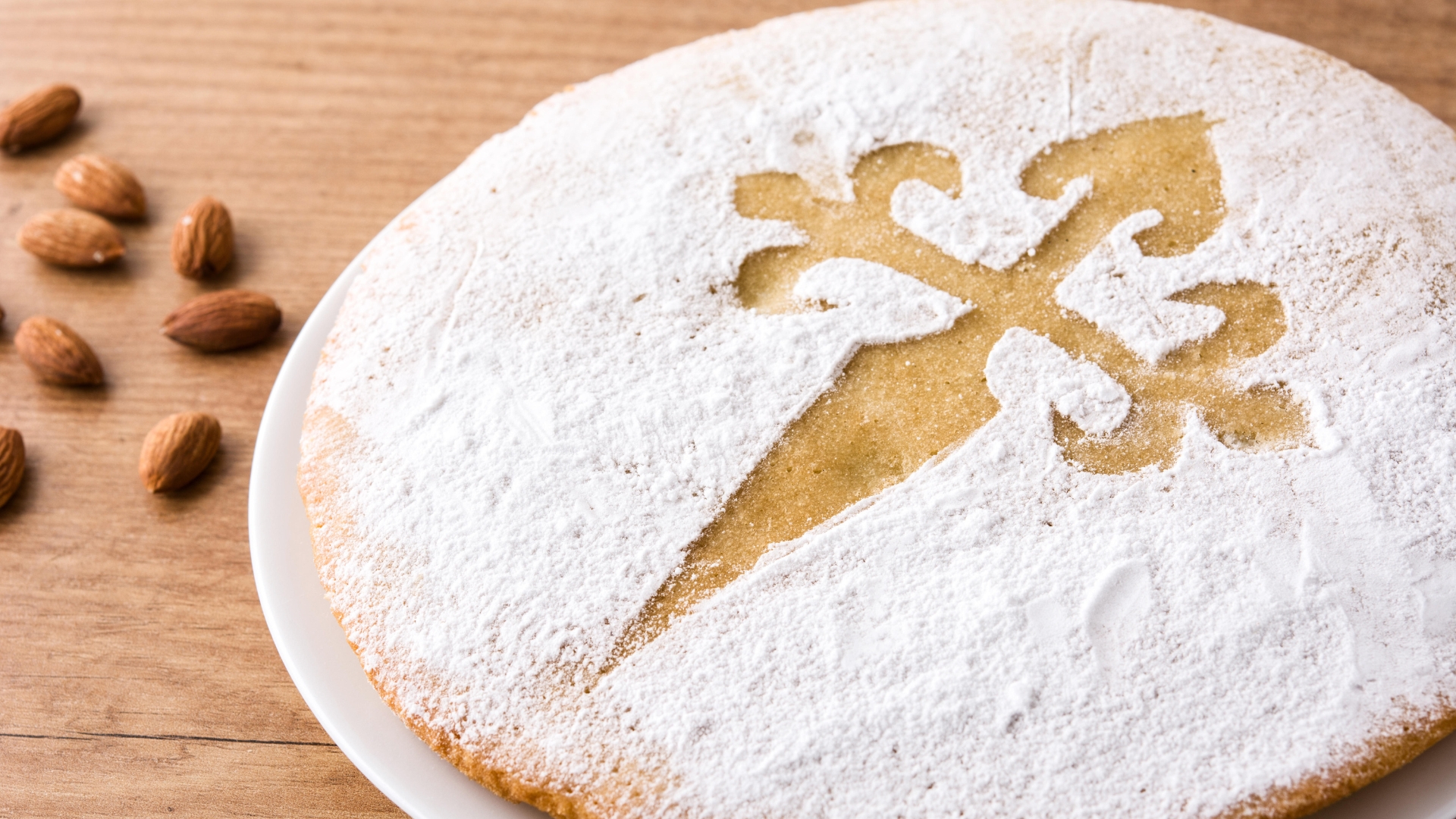 The Spanish cake Tarta de Santiago, a centuries-old almond cake from Galicia, topped with a powdered sugar stencil of the Cross of Saint James.